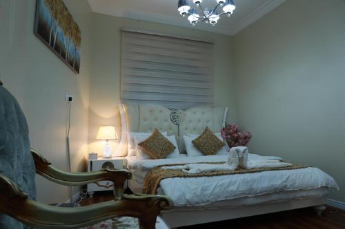 a bedroom with a bed with a chair and a lamp at Happy Day هابي دي 