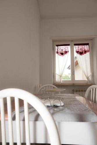a dining room with a table and two windows at Casa Remo in Valmontone