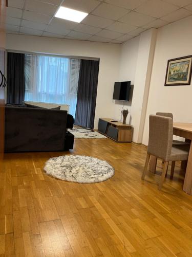 een woonkamer met een bank, een tafel en een tapijt bij Apartman 208 in Novi Sad