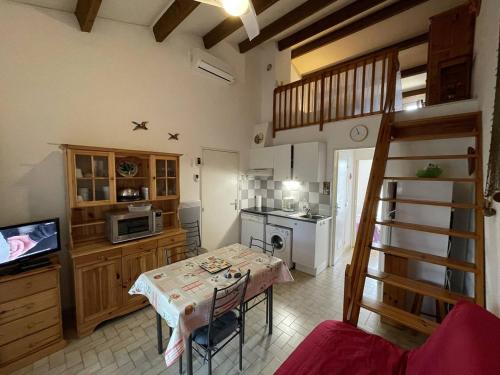 - une cuisine avec une table et une télévision dans la chambre dans l'établissement Villa Climatisée 3 Faces, 5-6 Pers, Garage, Proche Plage, Saint-Cyprien - FR-1-106-28, à Saint-Cyprien