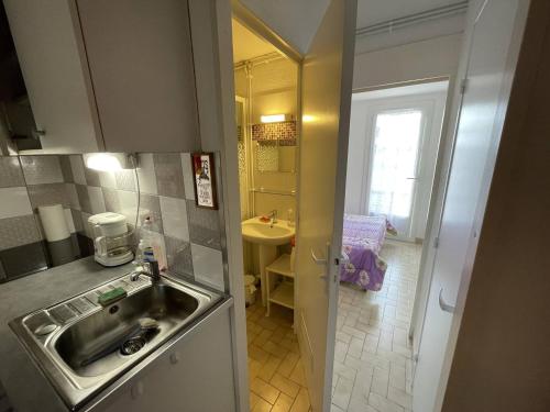 Il comprend une petite cuisine avec un évier et une salle de bains. dans l'établissement Villa Climatisée 3 Faces, 5-6 Pers, Garage, Proche Plage, Saint-Cyprien - FR-1-106-28, à Saint-Cyprien