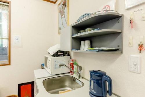 a kitchen with a sink and a microwave at Sakai Kita-ku - House - Vacation STAY 10593 in Asakayamachō