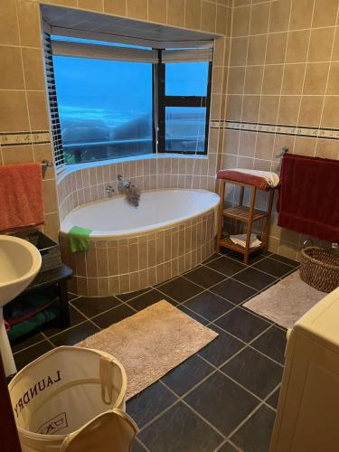a bathroom with a bath tub and a window at Makarios in Great Brak River