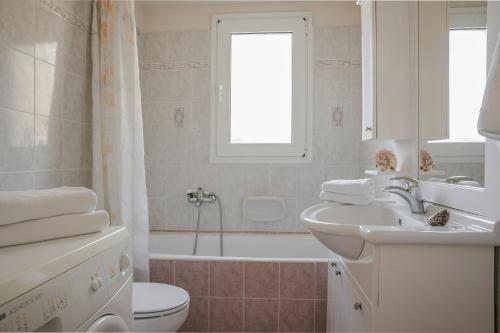y baño con lavabo, aseo y bañera. en Kefalonian Sea View Home, en Svoronata
