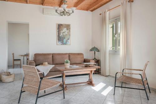 sala de estar con sofá, mesa y sillas en Kefalonian Sea View Home, en Svoronata