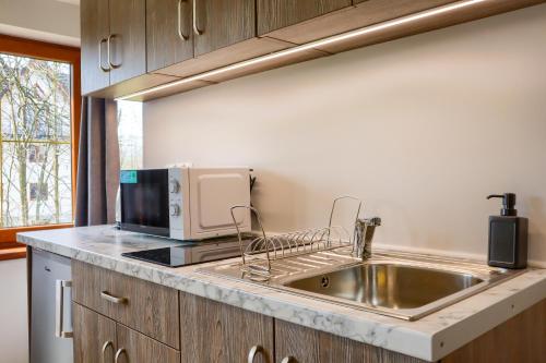 a kitchen with a sink and a microwave at Apartments Pod Jaworami in Białka Tatrzańska