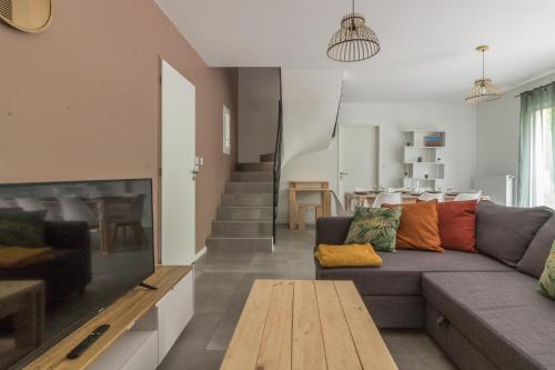 a living room with a couch and a table at Les Villas de Castel - Villa Les frênes in Castelmaurou