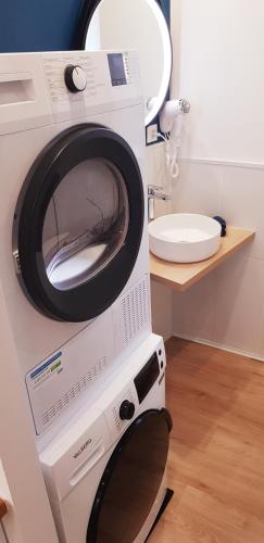 une machine à laver dans une salle de bain avec un lavabo dans l'établissement Escapade Niortaise - Studios climatisés hyper-centre de Niort, à Niort