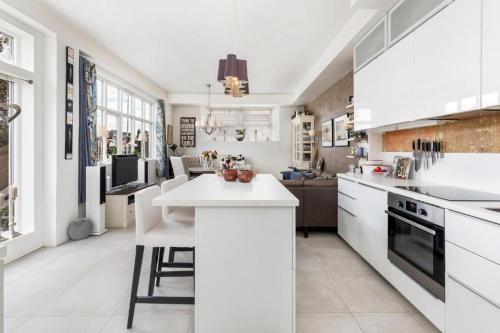 a kitchen with white cabinets and a white counter top at Stylish apartment with beautiful views of the river, beach nearby in Kristiansand