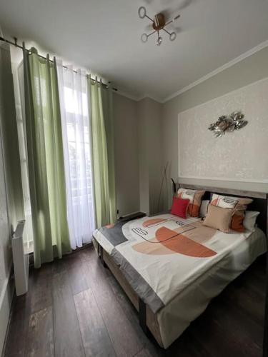 une chambre avec un grand lit avec des rideaux verts dans l'établissement Plein cœur du centre historique de Perigueux ., à Périgueux