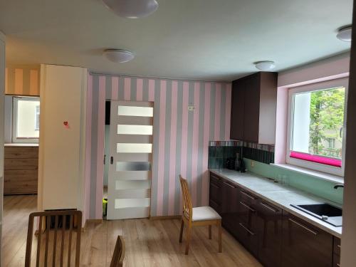 una cocina con una pared de rayas rosa y blanca en Apartament Batorego 2a en Gdansk