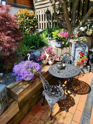 a garden with a table and chairs and flowers at Gästehaus Engelgasse Herzogenaurach in Herzogenaurach