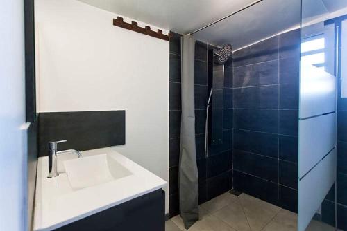 y baño con lavabo y ducha. en L'escapade créole Jacuzzi Privatif Studio Litchi, en Saint-Joseph