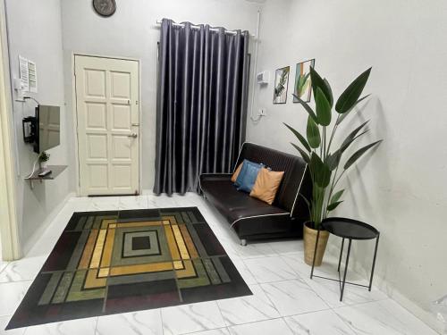 a living room with a couch and a chair at Aufa Homestay 2 Bilik Aircond in Pendang