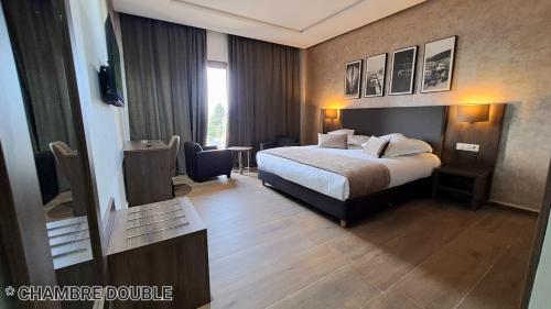 um quarto de hotel com uma cama e uma mesa em Hotel Jaouharat Ismaili em Meknès