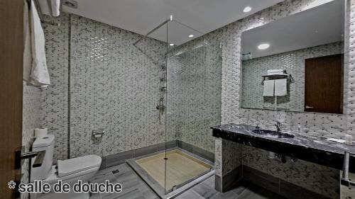 La salle de bains est pourvue d'une douche, d'un lavabo et d'un miroir. dans l'établissement Hotel Jaouharat Ismaili, à Meknès