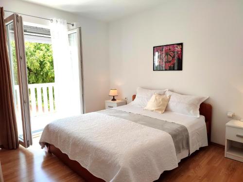 1 dormitorio con cama blanca y ventana grande en House Kuna, en Brištane