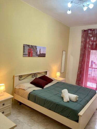 um quarto com uma cama grande e um cobertor verde em sentiti a casa-guest house em Nápoles