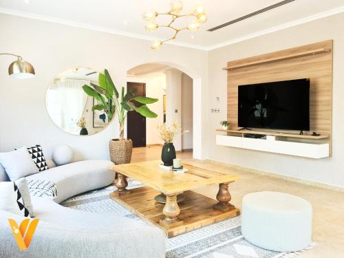 a living room with a couch and a table at Luxury 3BR Private Pool Villa and Elaborate Gardens in Dubai