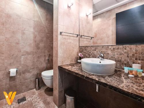 Luxury 3BR Private Villa and Elaborate Gardens في دبي: حمام مع حوض ومرحاض
