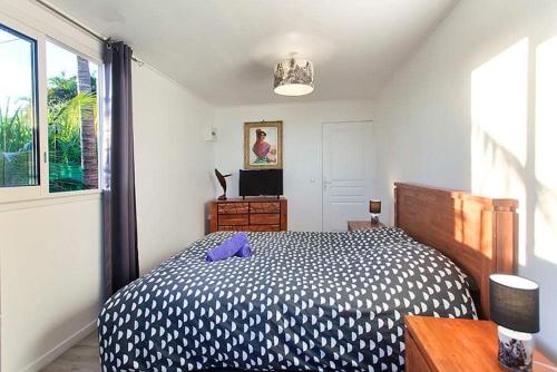 聖若瑟的住宿－L'escapade créole Jacuzzi Privatif Bungalow Vanille，一间卧室配有一张带紫色枕头的床