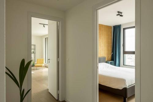 1 dormitorio con cama y espejo grande en UNIEK appartement -zicht Schelde en Amberes