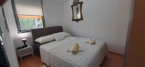 a bedroom with a bed with two towels on it at Apartman Olive grove in Rogoznica