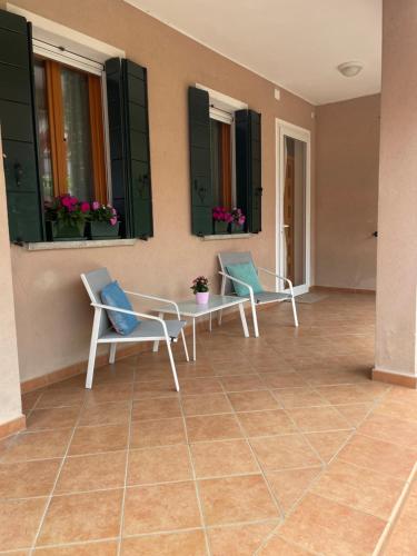 a patio with two chairs and a table and windows at A Casa dei Nonni in Cavallino-Treporti
