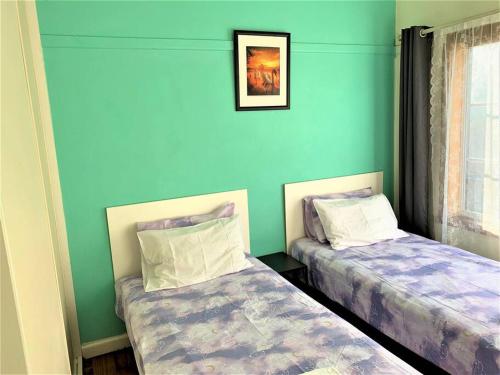 two beds in a room with blue walls at Easy Self Check-in accomodation in Springvale