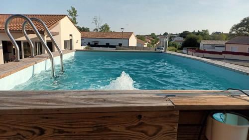 une grande piscine avec une terrasse en bois dans l'établissement Chambre douillette, calme, lit queen size wifi, à Avrillé