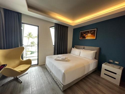 a hotel room with a large bed and a chair at Stardust Boutique Hotel in Hua Hin