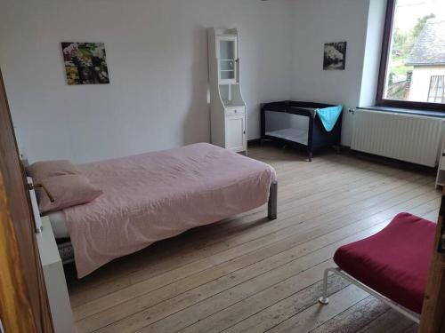 a bedroom with a bed and a desk and a window at Granny Cottage. in Marchin