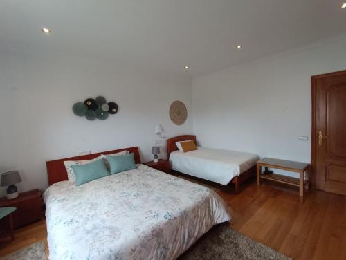 a bedroom with two beds and a table at Casa Grande in Golpilheira