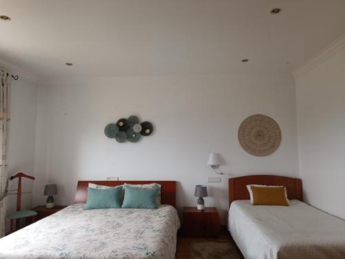 a bedroom with two beds and a white wall at Casa Grande in Golpilheira