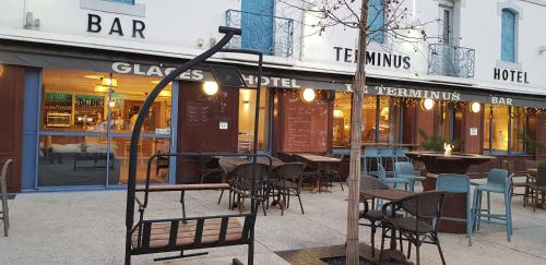 a restaurant with tables and chairs in front of a building at Hôtel Terminus in Luz-Saint-Sauveur