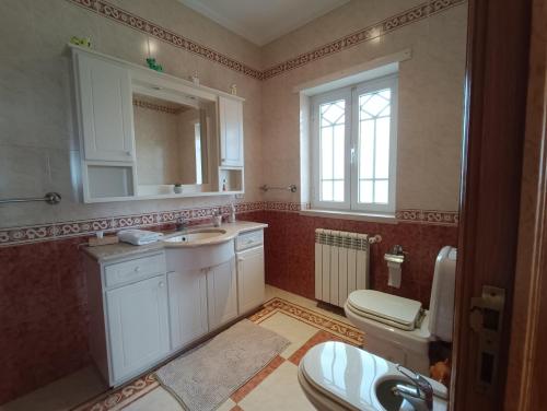 a bathroom with a sink and a toilet and a mirror at Casa Grande in Golpilheira