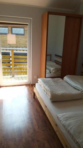 two beds in a room with a large window at Apart Magda 2 in Rewal