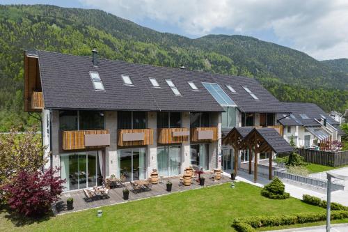 ein großes Haus mit einem Berg im Hintergrund in der Unterkunft Boutique Skipass Superior Hotel in Kranjska Gora