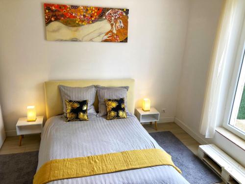 Un dormitorio con una cama con dos lámparas y un cuadro. en Blue Summer Vibes - Studio duplex 3 - AC, parking, beach at 50m, SPA discnt, en La Ciotat
