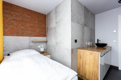 1 dormitorio con cama y pared de ladrillo en Hostel Dzika Kaczka, 