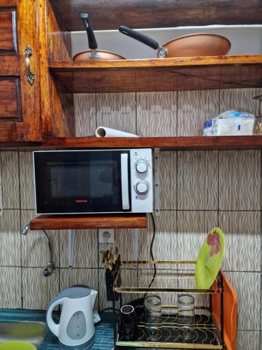 a microwave sitting on top of a kitchen counter at La Cité des Anges in Nkongsamba