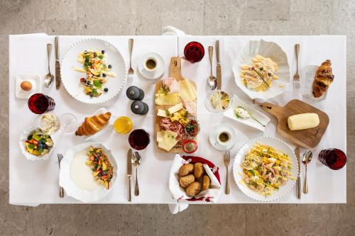 a white table with plates of food on it at Boutique Skipass Superior Hotel in Kranjska Gora