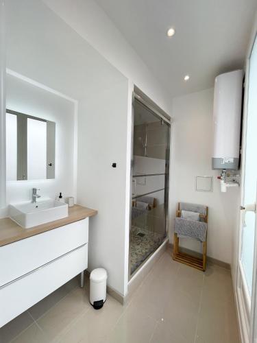 une salle de bain blanche avec un lavabo et un miroir dans l'établissement Hyper Centre, balcon, emplacement & vue incroyable, spacieux, à Amiens
