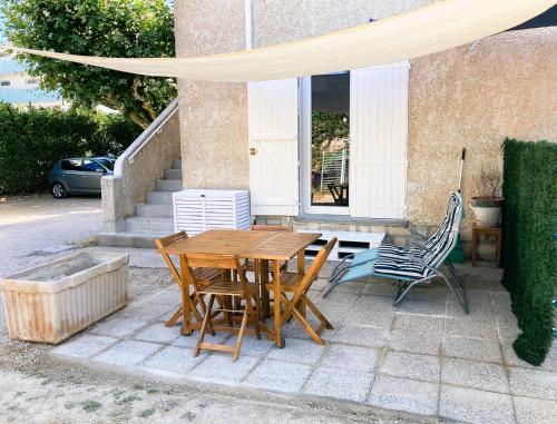 a wooden table and chairs sitting outside of a house at Blue Summer Vibes Duplex Studio for 4P, AC, sea view, parking, beach at 50m, SPA access -3 in La Ciotat