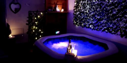 a room with a blue tub with candles and lights at La Manch'hôtes in Domjean