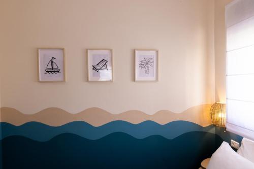 a room with four pictures on a wall with at Domus Bat Galim Hotel in Haifa
