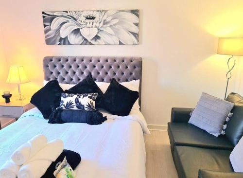 a bedroom with a large bed and a chair at Green Apartments in Invergowrie