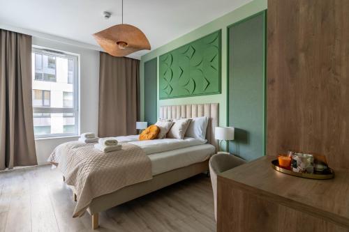格地尼亞的住宿－Symphony Modern Tower Aparthotel，一间卧室设有一张带绿色墙壁的大床