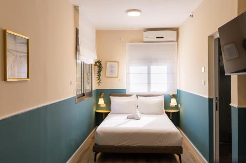 Domus Bat Galim Hotel في حيفا: غرفة نوم بسرير وملاءات بيضاء ونافذة
