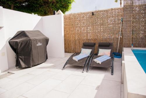 2 chaises et une tente à côté de la piscine dans l'établissement Casa de Almano - Torremolinos direct on beach, à Torremolinos